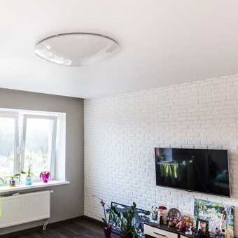 Простой сатиновый потолок в интерьере комнаты